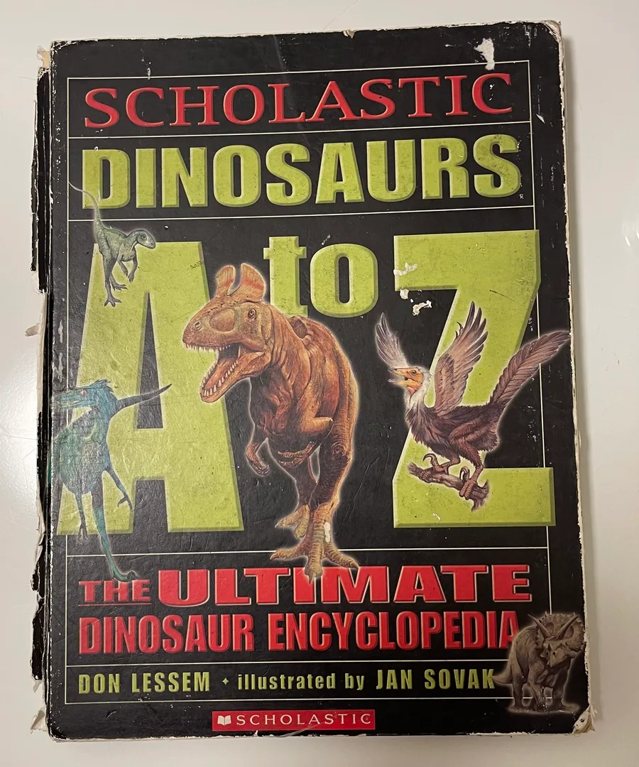 A battered copy of Scholastic Dinosaurs A to Z, illustrated by Jan Sovak, worn down to the spine.